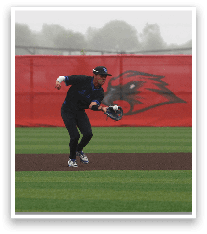 A baseball player wearing a blue shirt and black pants is catching a ball. Description generated by AI