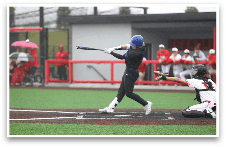 A baseball player in a blue helmet and black shirt swings a bat. Description generated by AI