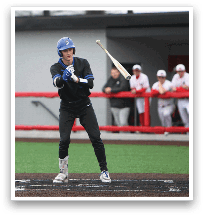 A baseball player in a black shirt and blue helmet is swinging a bat. Description generated by AI