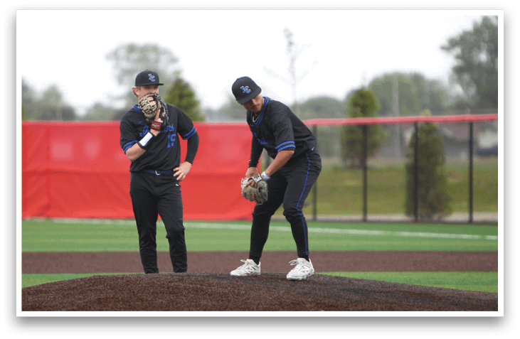 Two men wearing black baseball uniforms. Description generated by AI