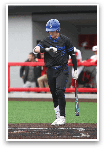A baseball player holding a bat and standing on a field. Description generated by AI