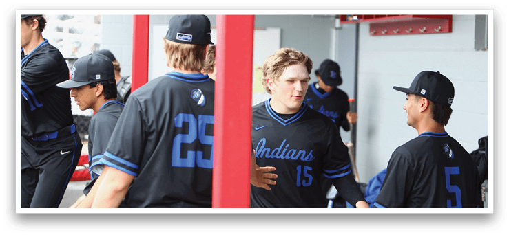 A group of baseball players wearing black jerseys with blue numbers and letters. Description generated by AI