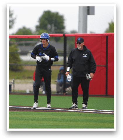 Two men standing on a baseball field. Description generated by AI