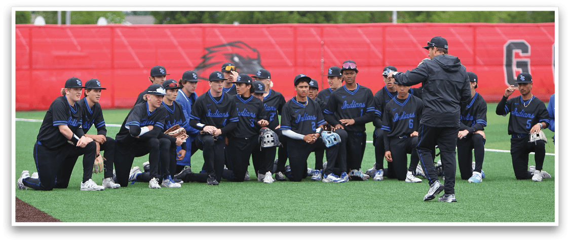 A group of baseball players wearing blue and black uniforms. Description generated by AI