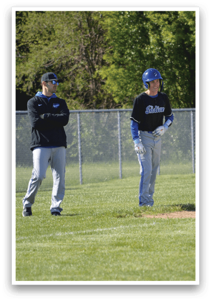 Two men walking on a baseball field. Description generated by AI