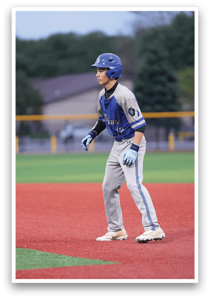 A baseball player wearing a blue helmet and grey uniform. Description generated by AI