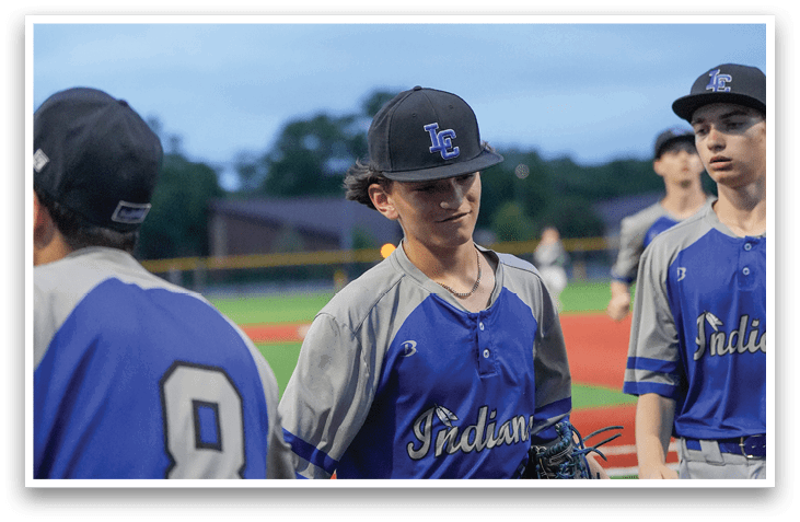 A baseball player wearing a blue shirt and grey pants. Description generated by AI