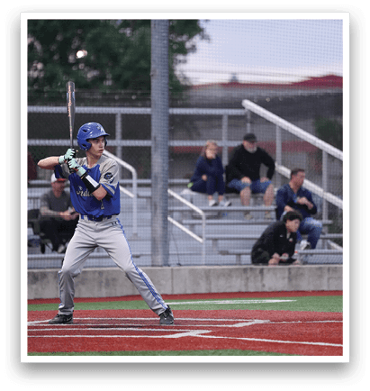 A baseball player in a blue and grey uniform holding a bat. Description generated by AI