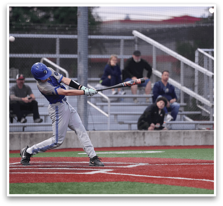 A baseball player in a blue helmet and grey pants is swinging a bat. Description generated by AI
