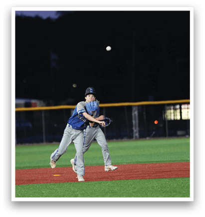 A baseball player in a blue shirt and grey pants is swinging a bat at a ball. Description generated by AI