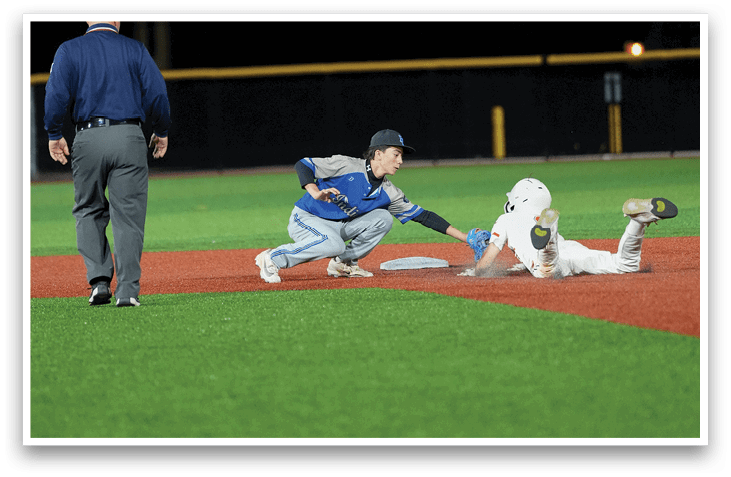 A baseball player slides into a base while the catcher tries to tag him out. Description generated by AI