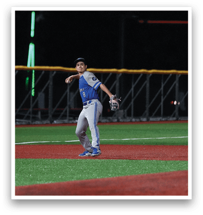 A baseball player in a blue and white uniform is standing on a field. Description generated by AI