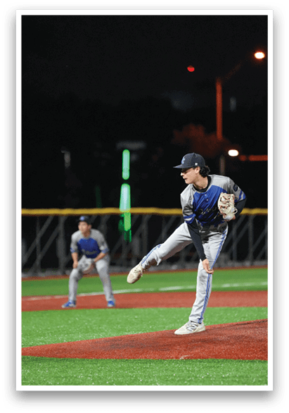 A baseball player in a blue and white uniform is pitching a ball. Description generated by AI