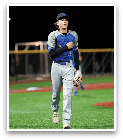 A baseball player wearing a blue and grey uniform. Description generated by AI