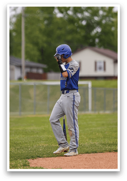 A baseball player wearing a blue helmet and grey uniform. Description generated by AI