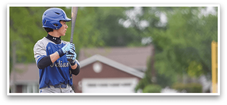 A baseball player in a blue and grey uniform holding a bat. Description generated by AI