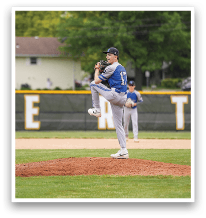A baseball player in a blue shirt and grey pants is pitching a ball. Description generated by AI