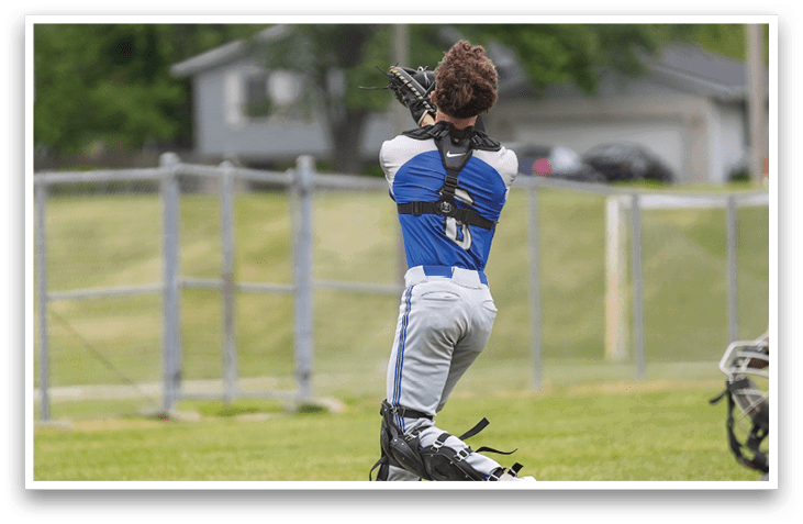 A baseball player in a blue and white uniform is swinging a bat at a ball. Description generated by AI