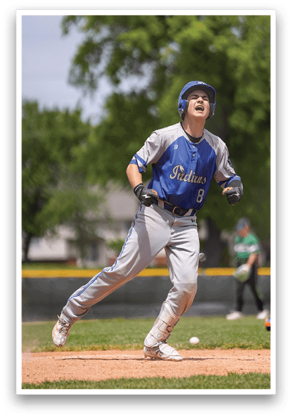 A baseball player wearing a blue and white uniform is running towards home plate. Description generated by AI