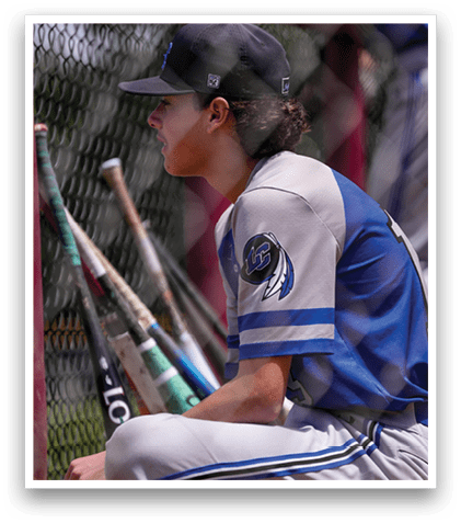 A baseball player wearing a blue and white uniform with a bat in his hand. Description generated by AI