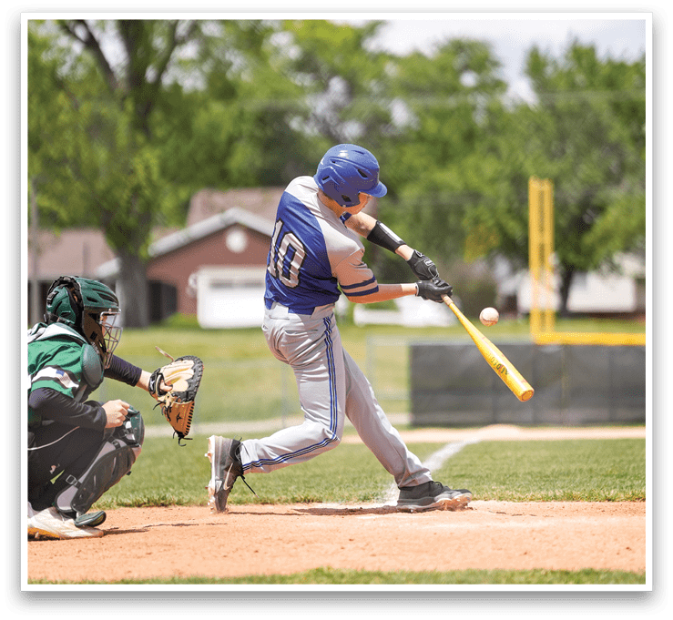 A baseball player in a blue helmet and grey uniform is swinging a bat. Description generated by AI
