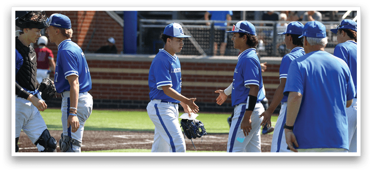 A group of baseball players wearing blue and white uniforms. Description generated by AI