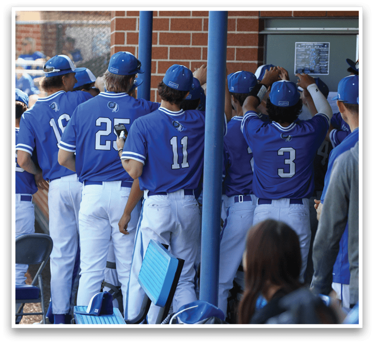 A group of baseball players wearing blue and white uniforms. Description generated by AI