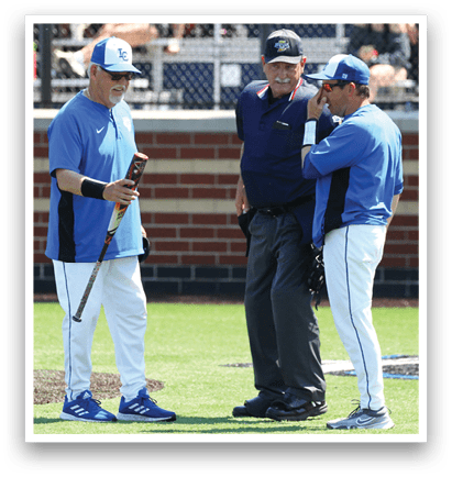 A baseball field with two men talking to an umpire. Description generated by AI