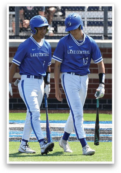 Two baseball players wearing blue and white uniforms. Description generated by AI