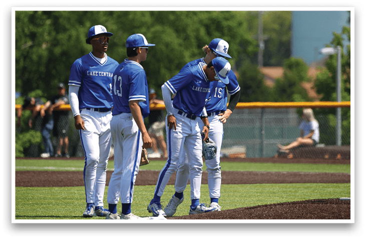 A group of baseball players wearing blue and white uniforms. Description generated by AI