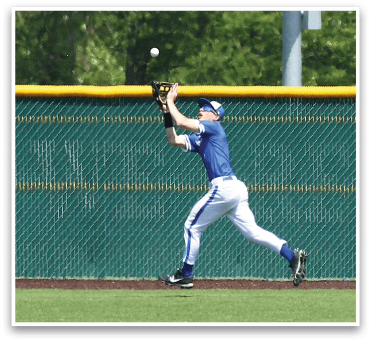 A baseball player wearing blue and white catching a ball. Description generated by AI