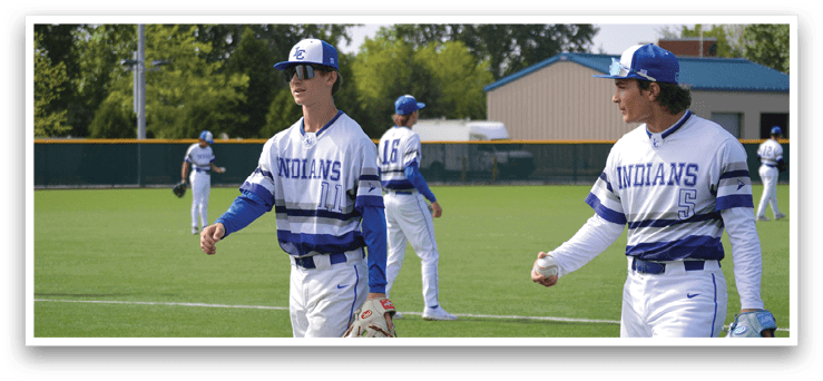 Two baseball players wearing blue and white uniforms. Description generated by AI