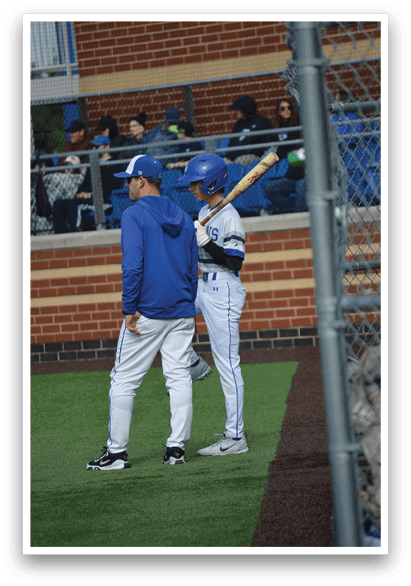 A baseball player holding a bat. Description generated by AI