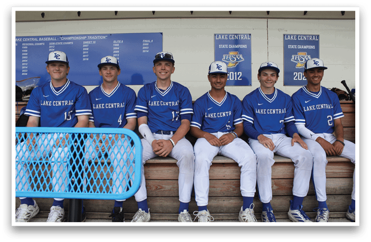 A group of baseball players in blue uniforms sitting on a bench. Description generated by AI