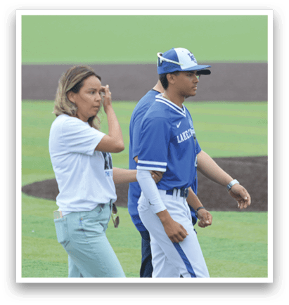 A man and a woman walking on a baseball field. Description generated by AI