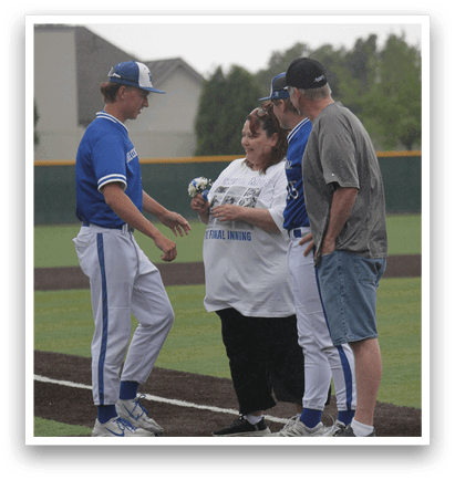 A group of people standing on a baseball field. Description generated by AI
