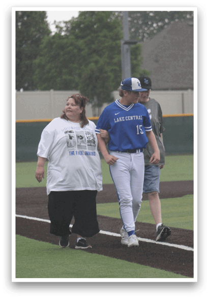 A man and woman walking on a baseball field. Description generated by AI