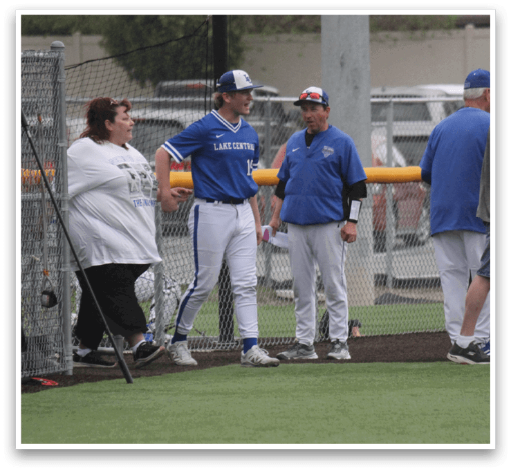 A group of baseball players standing on a field. Description generated by AI