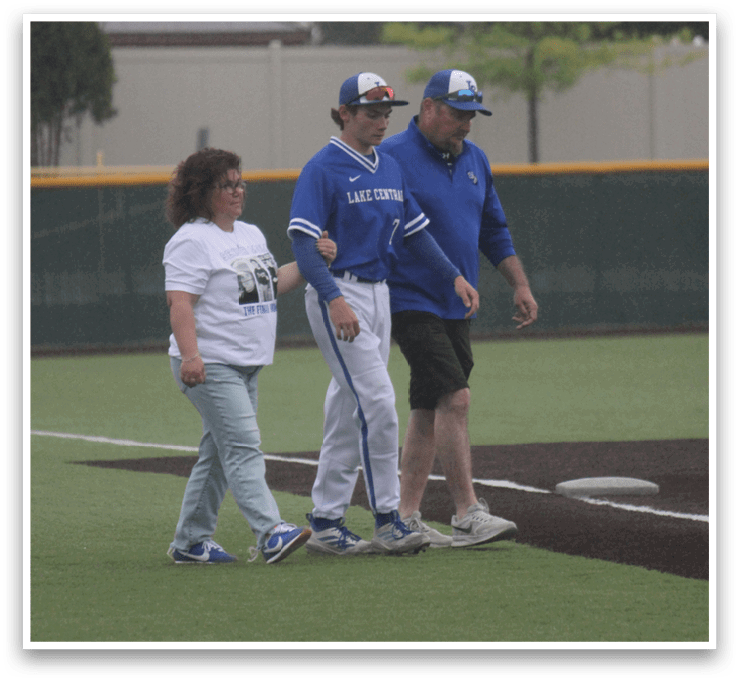 Three people walking on a baseball field. Description generated by AI