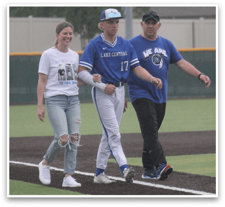 A man wearing a blue shirt and white pants is walking with two other people. Description generated by AI
