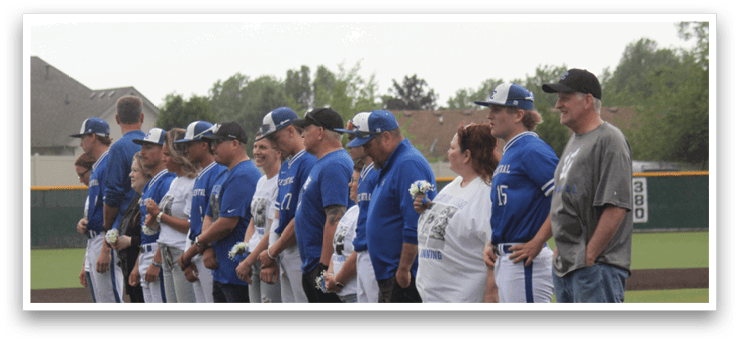 A group of people standing on a baseball field. Description generated by AI