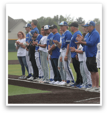 A group of people standing on a baseball field. Description generated by AI