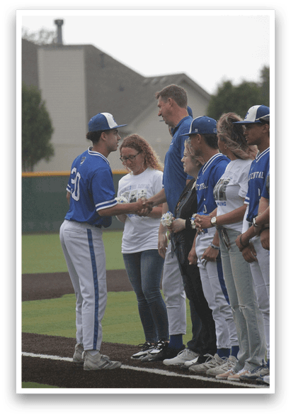 A group of people standing on a baseball field. Description generated by AI
