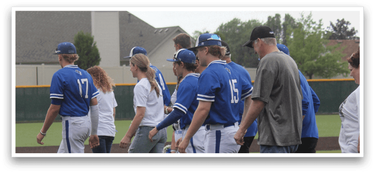 A group of people wearing blue and white uniforms are walking on a field. Description generated by AI