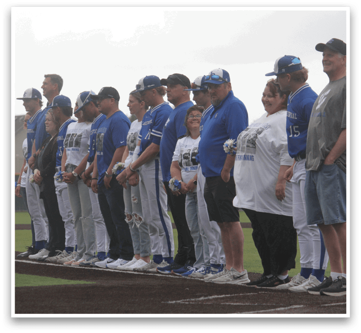 A group of people standing on a baseball field. Description generated by AI