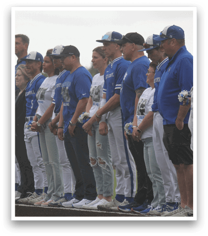 A group of people wearing blue shirts and white pants. Description generated by AI