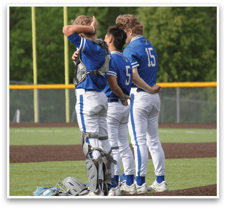 A group of baseball players standing on a field. Description generated by AI
