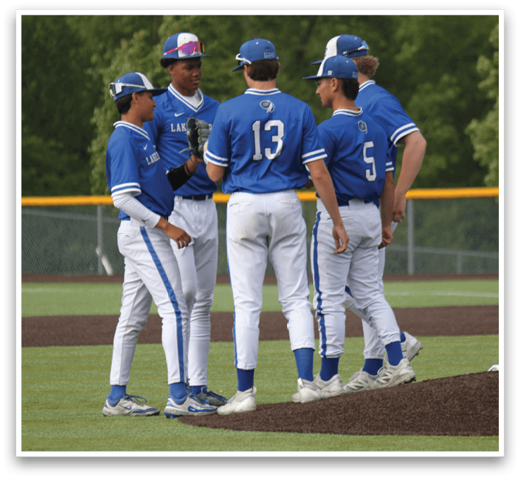 A group of baseball players wearing blue and white uniforms. Description generated by AI