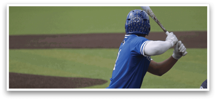 A baseball player in a blue and white uniform is swinging a bat. Description generated by AI