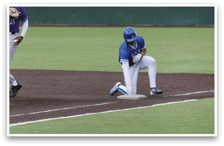 A baseball player kneeling on the field. Description generated by AI